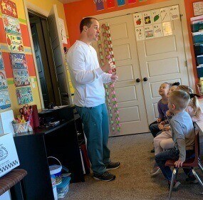 Doctor Cline teaching class of kids about oral health