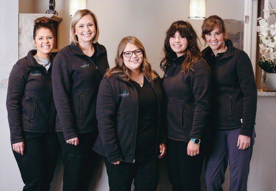 Five smiling members of the Cline Family and Cosmetic Dentistry team